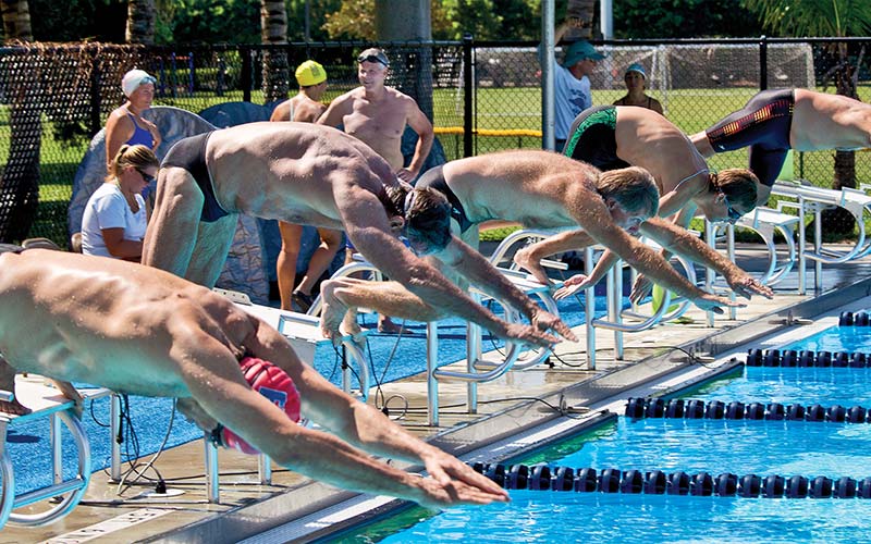 Old men in a swimming race jump off their starting blocks