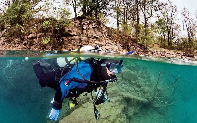 Over-under shot of a diver in a quarry