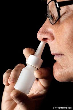 Person injects nasal spray into left nostril