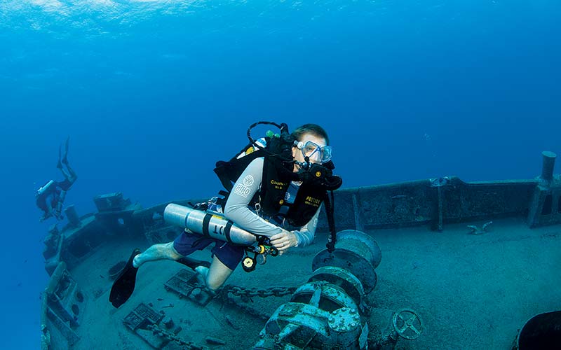 Rebreather diver swims above a shipwreck