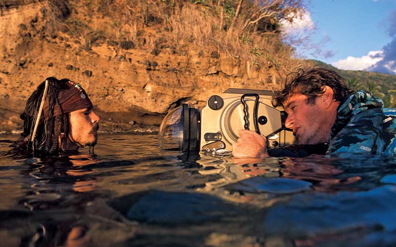 Underwater cinematographer Zuccarini gets a head-on shot of Captain Jack Sparrow. Both bodies are fully submerged in water, but heads are sticking out