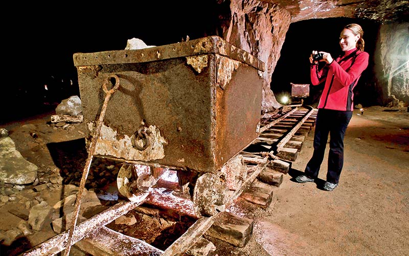 Woman takes a photo of an old mining cart