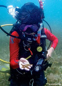 Young diver holds a starfish