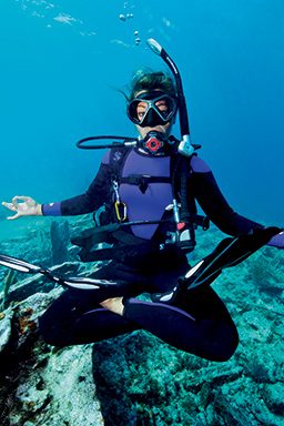 Female diver in crossed-legged position overs in water