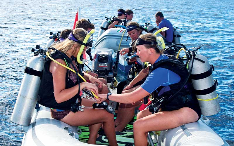 Group of divers on small boats getting ready for diving