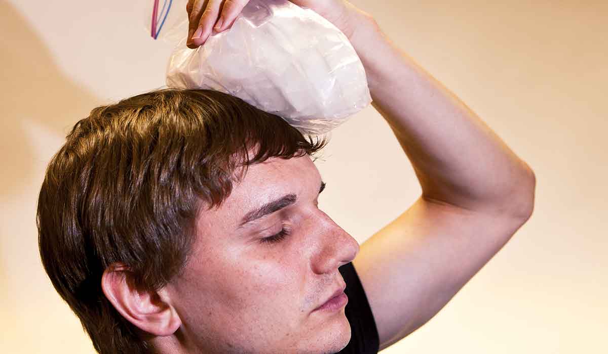 Man holds ice pack to his bonked head
