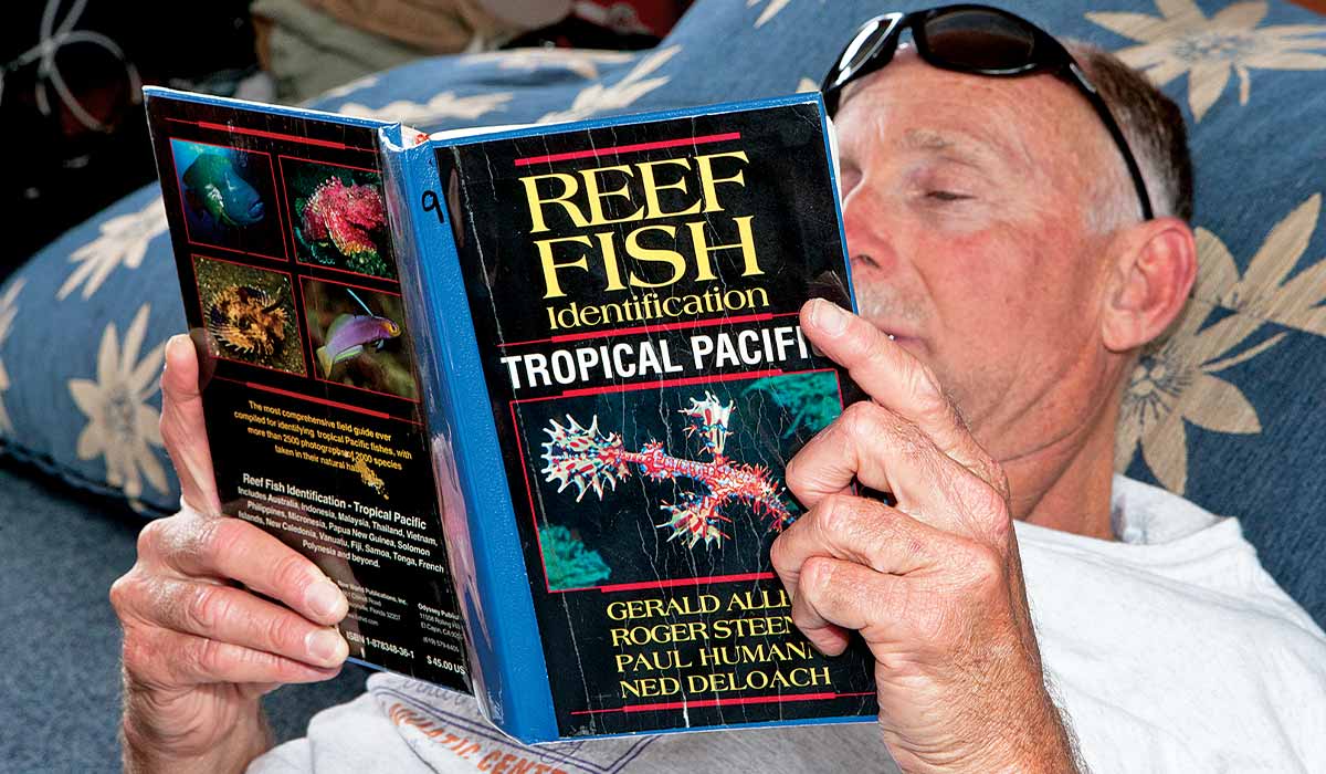 Man reads an old book on reef fish