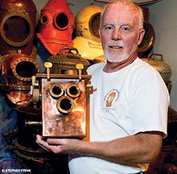 Museum curator holds up an antique camera replica