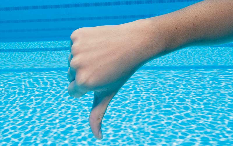 Submerged right hand in a thumbs-down position