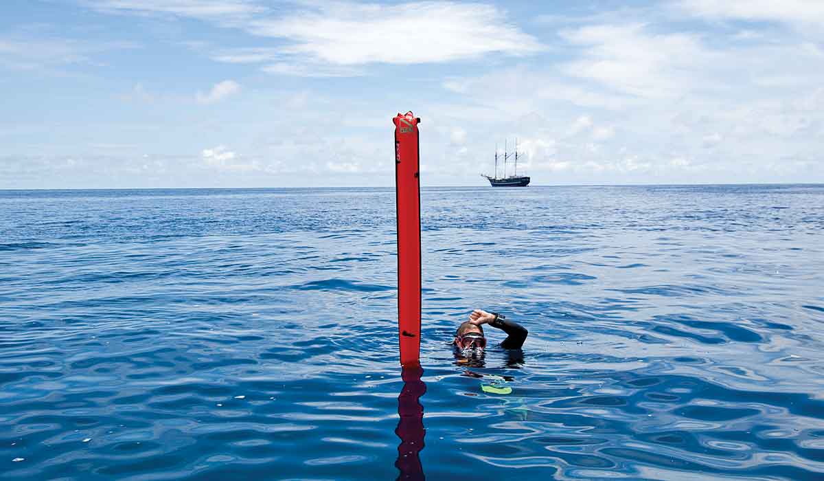 Surfaced diver floats next to red marker