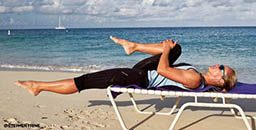 Woman lies on adjustable reclining lounger with one knee bent toward chest 256