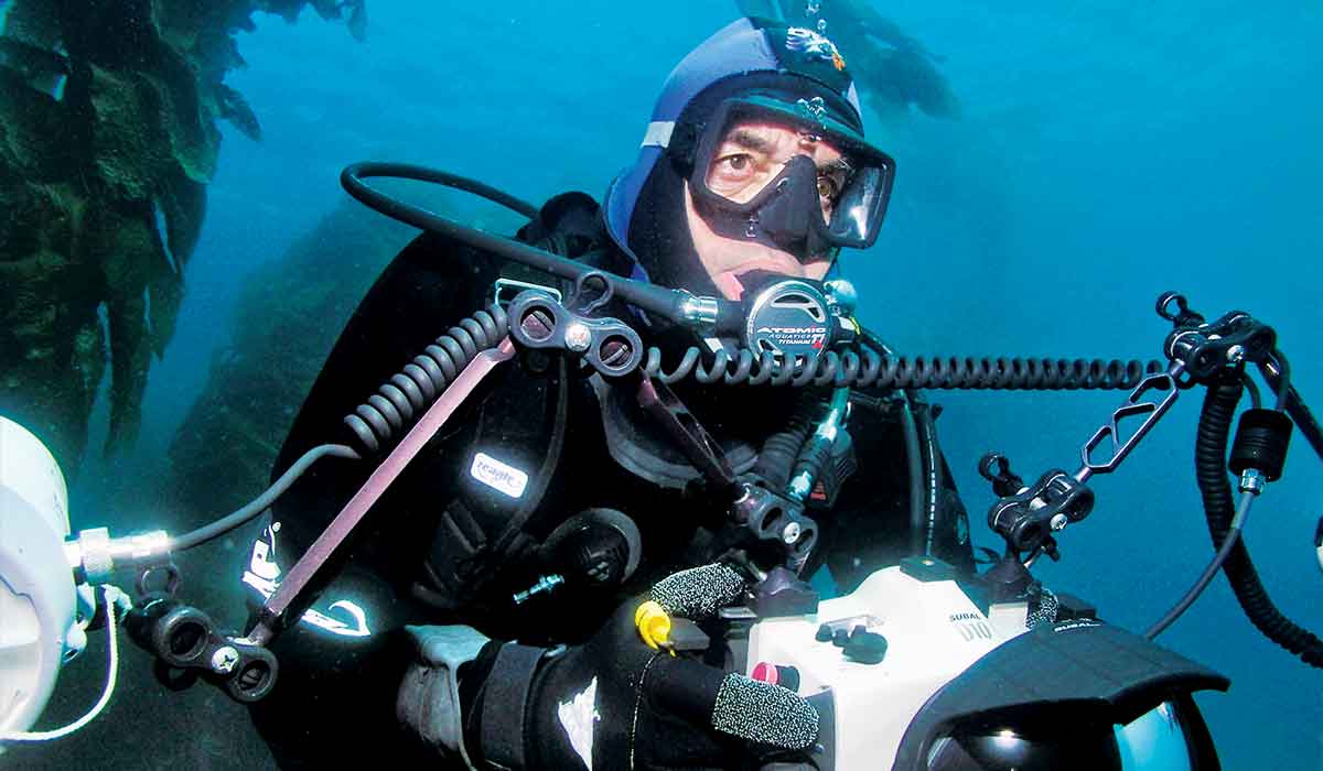 Advanced-skills diver holds a camera and stares off into a distance