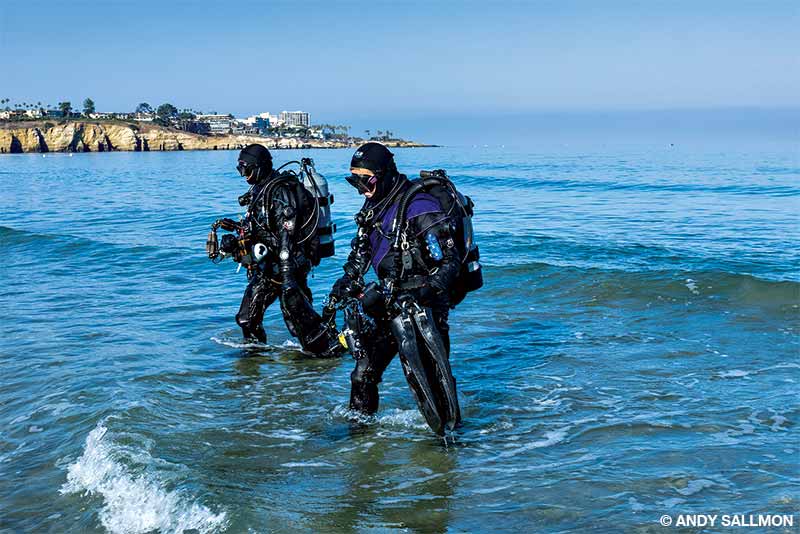buceadores saliendo del mar hacia la playa