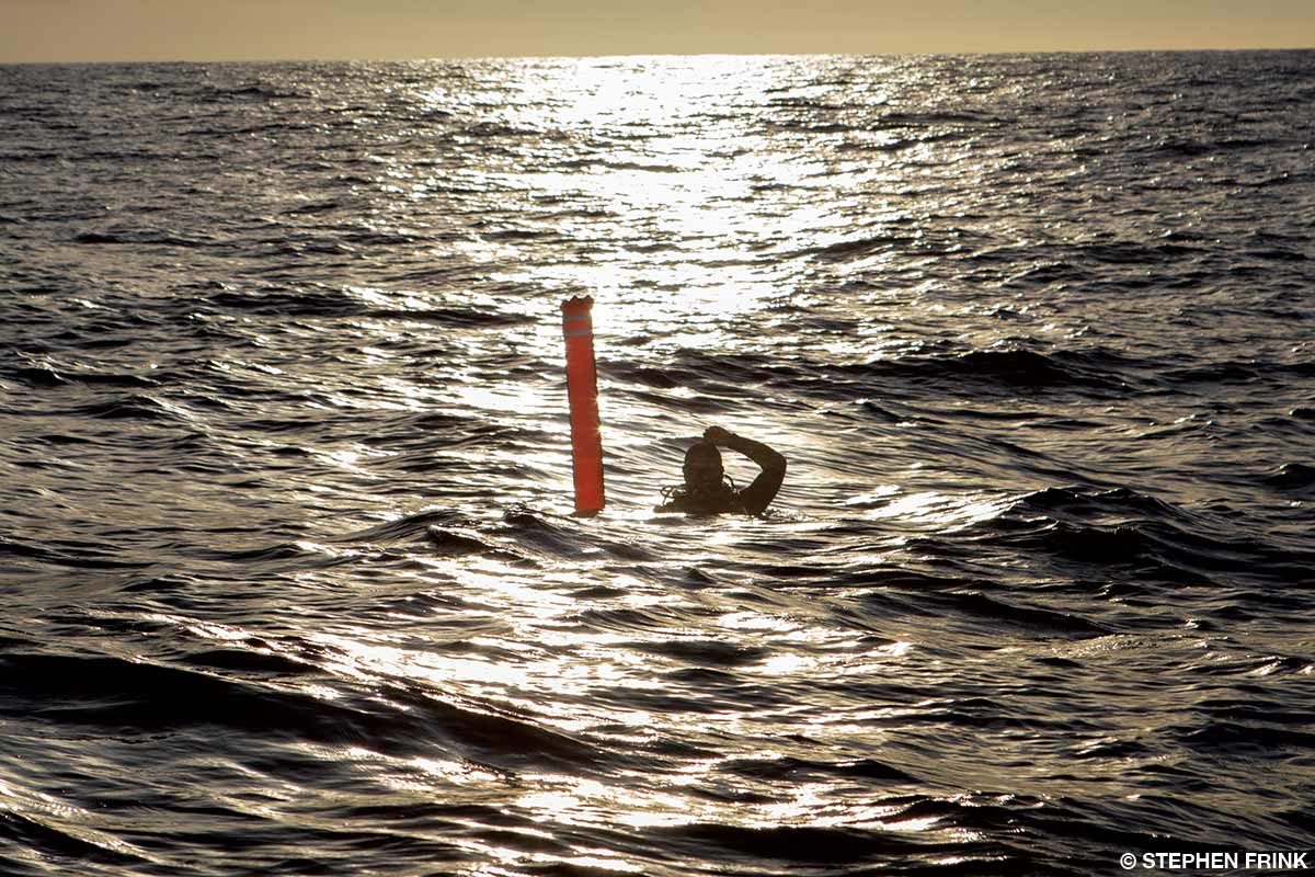 diver in the ocean with a surface signaling buoy