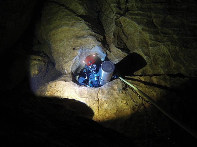 Buzzacott exiting through a restriction in the Source de la Douix cave, Châtillon-sur-Seine, France