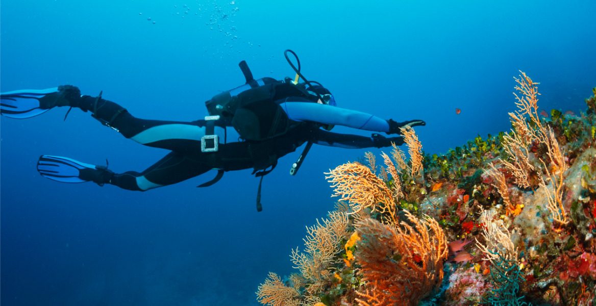 A diver caught in a current tucks in behind a reef.