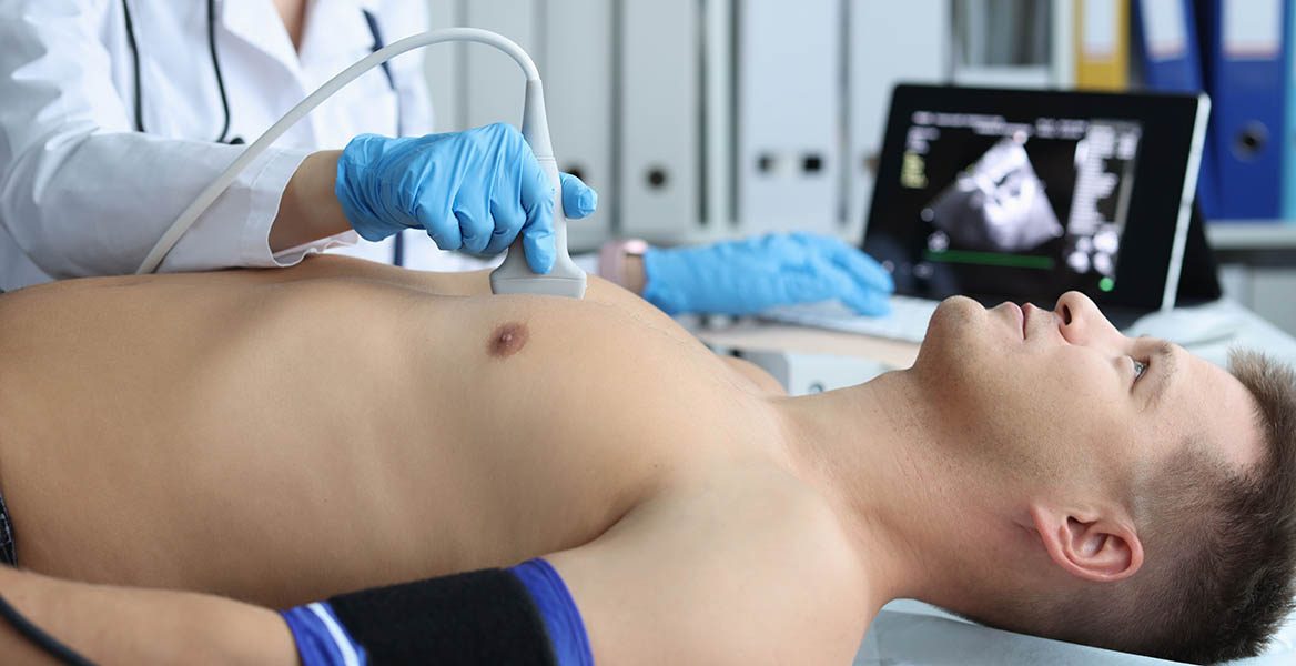 A medical provider uses ultrasound technology to observe a patient's heart.