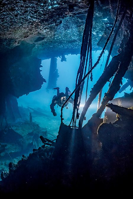 Evan Gill illuminates exposed cables on the Prinz Eugen wreck