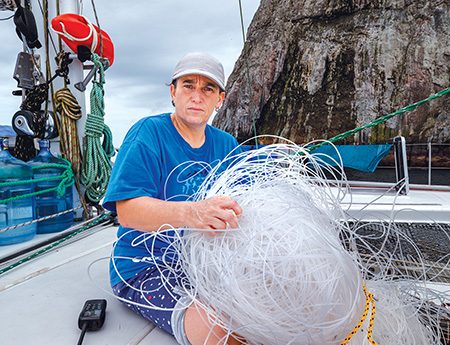 Erika Lopez holds a ball of long line recovered by her crew.