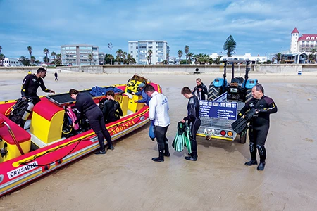 Divers load gear onto a rigid-hull inflatable boat