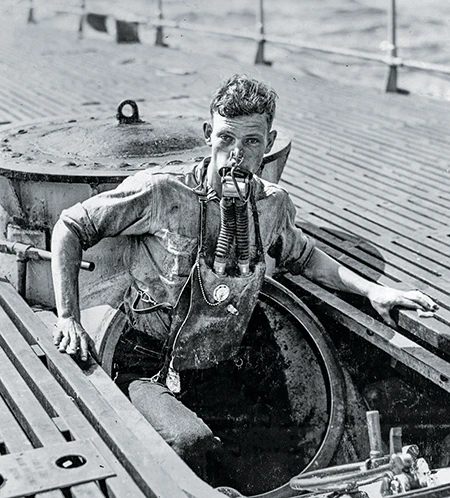 Crewman A.L. Rosenkotter exits a submarine’s escape hatch