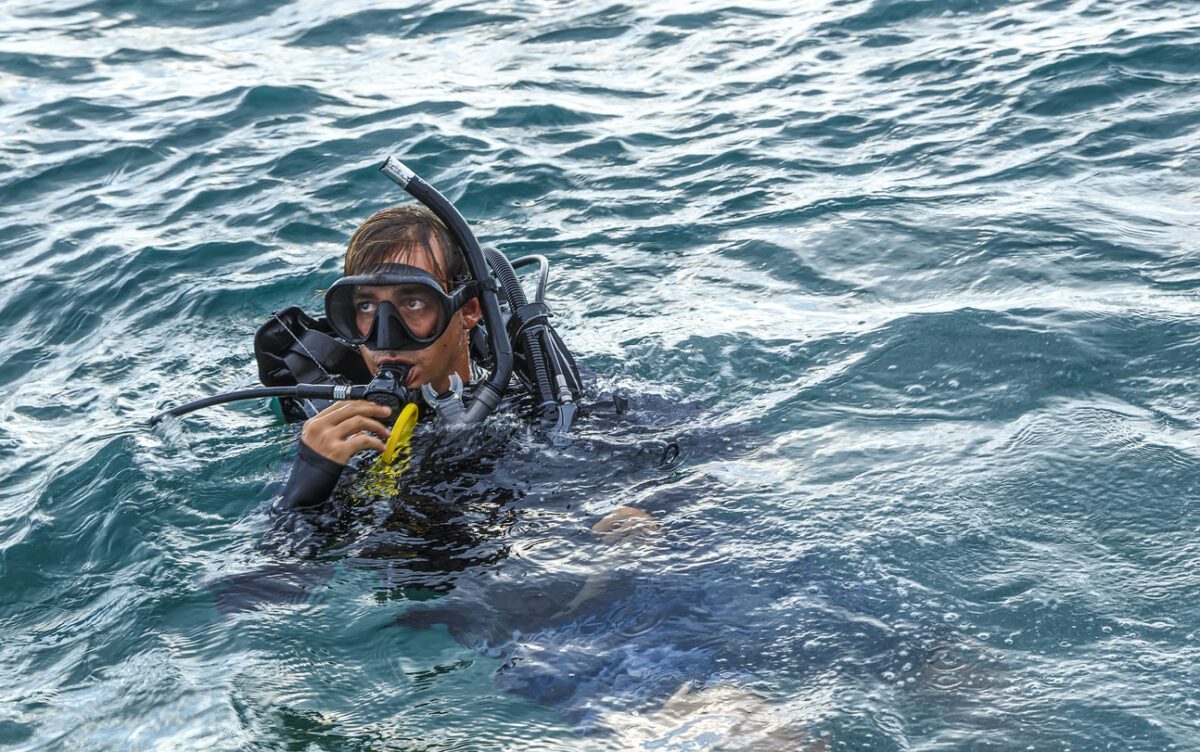 male diver on surface looking over his shoulder