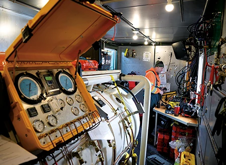 Surface operations aboard the barge include an onsite hyperbaric recompression chamber