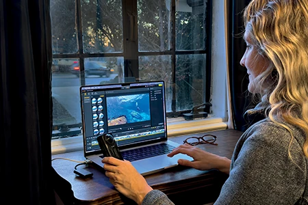 Woman on laptop with editing software