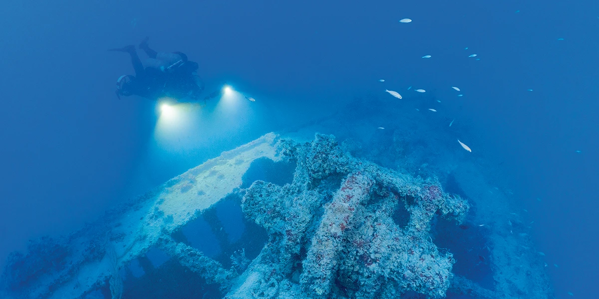 Diver Jason Cook illuminates the anchor windlass on the foredeck of HMCS Canada.