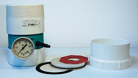 An exhaust valve pressure chamber with gasket, 4-inch (10-cm) knockout test cap, O-ring, washer, and female adapter