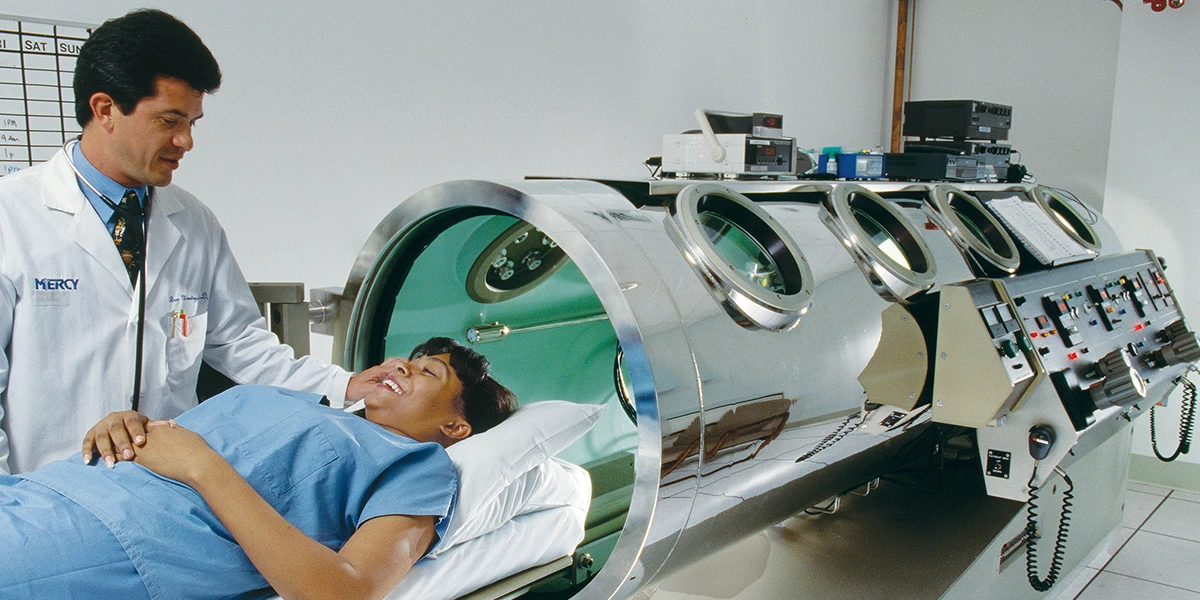 Doctor assisting patient into the chamber.